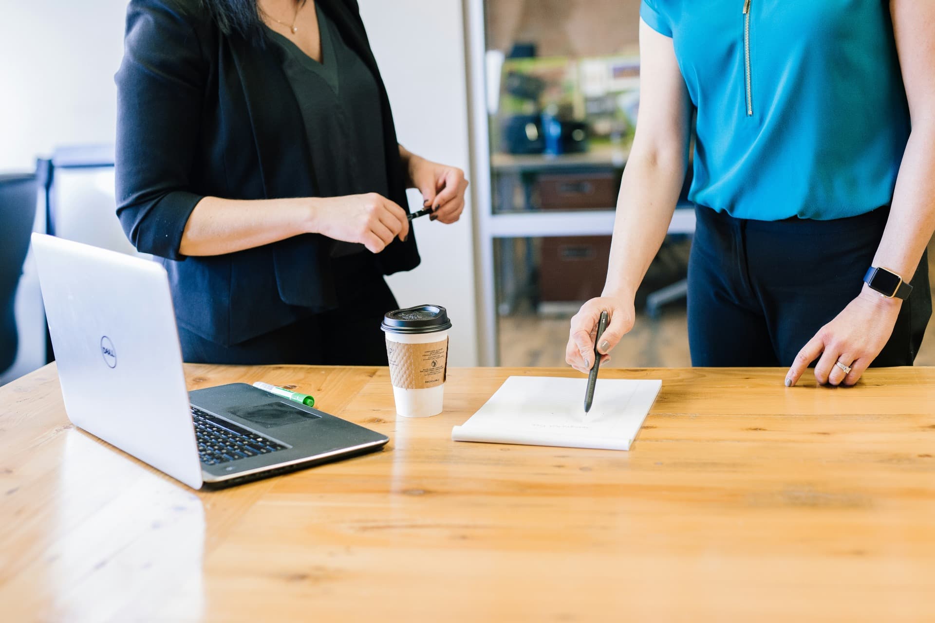 Mains qui remplissent un plan d'action étape par étape dans un carnet, tasse de café à côté