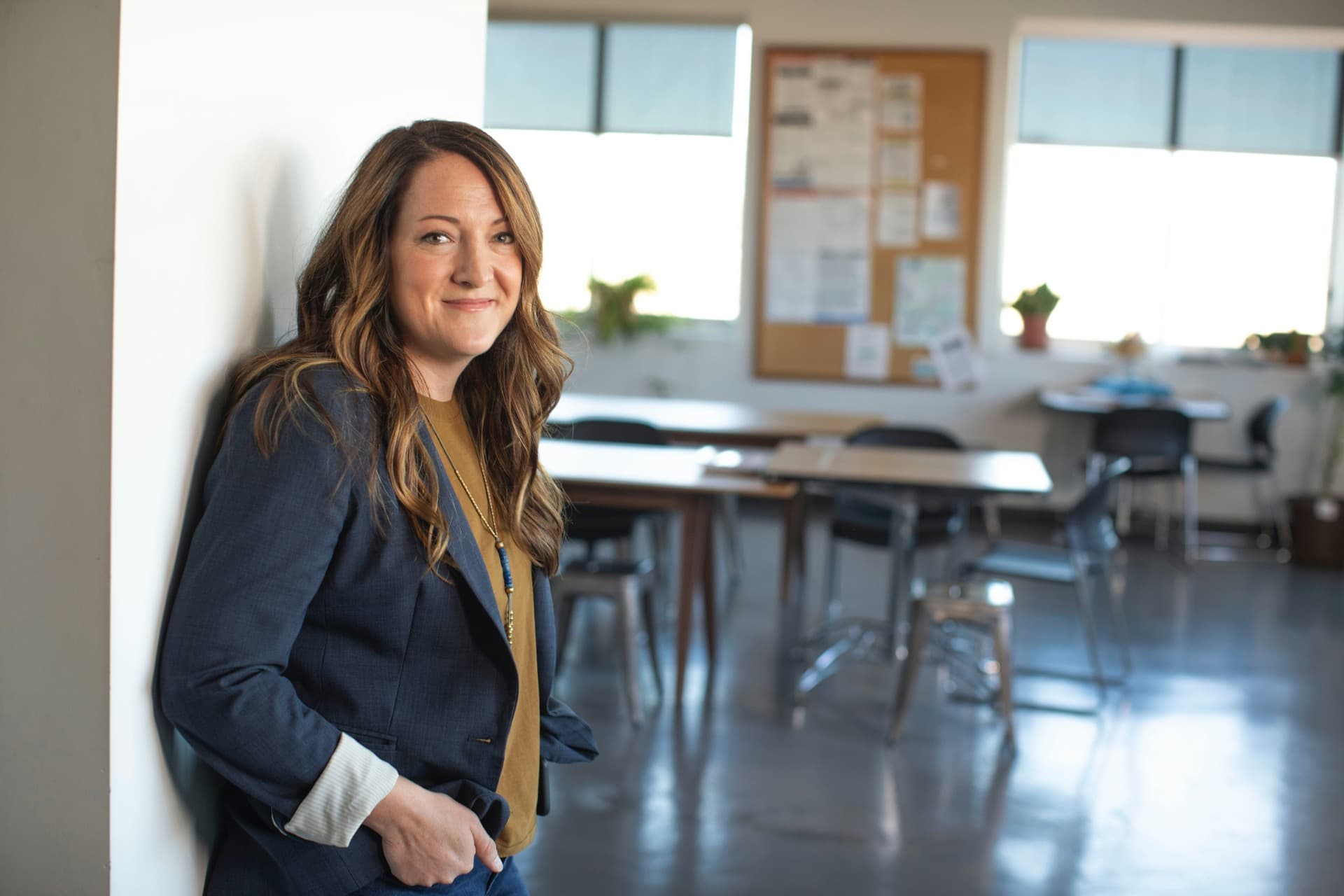 Responsable d'organisme de formation, posée dans une salle de classe vide, prête pour son audit Qualiopi